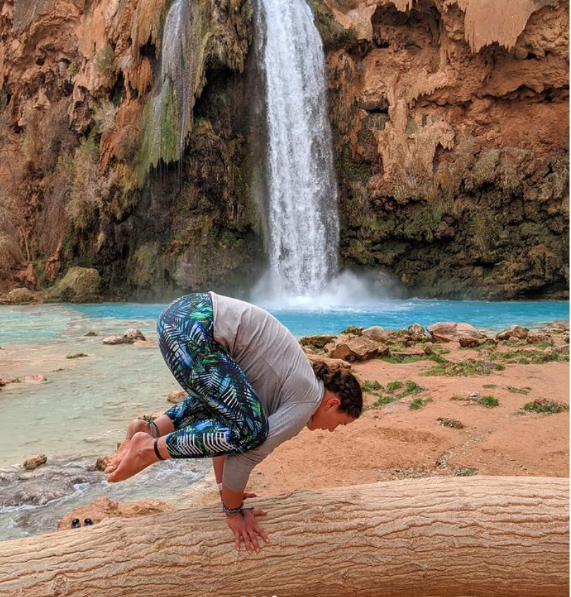 Elly in crow pose on a log in front of Havasu Falls, Arizona