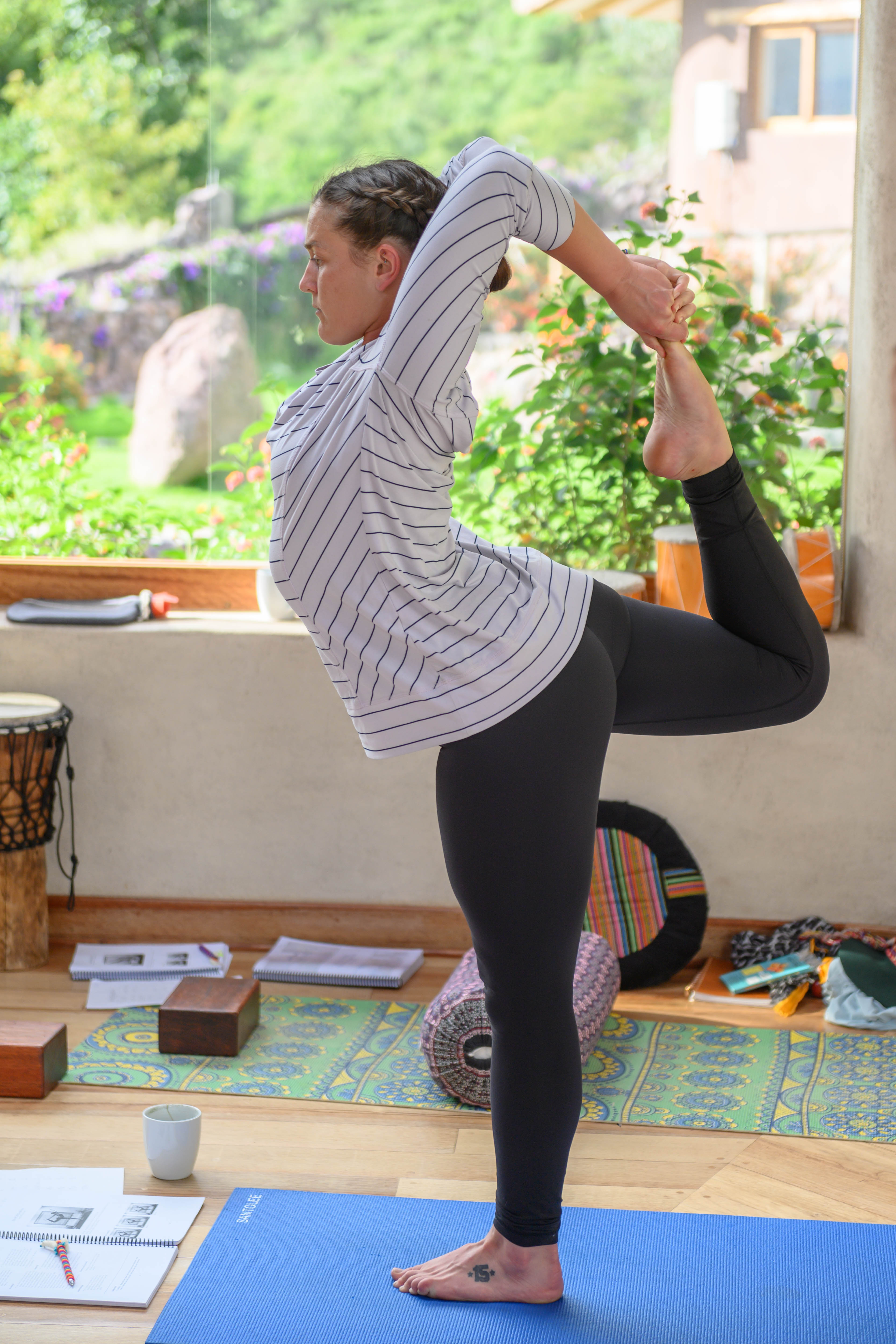 Elly in dancer pose at the Sacred Valley in Peru with lush greenery