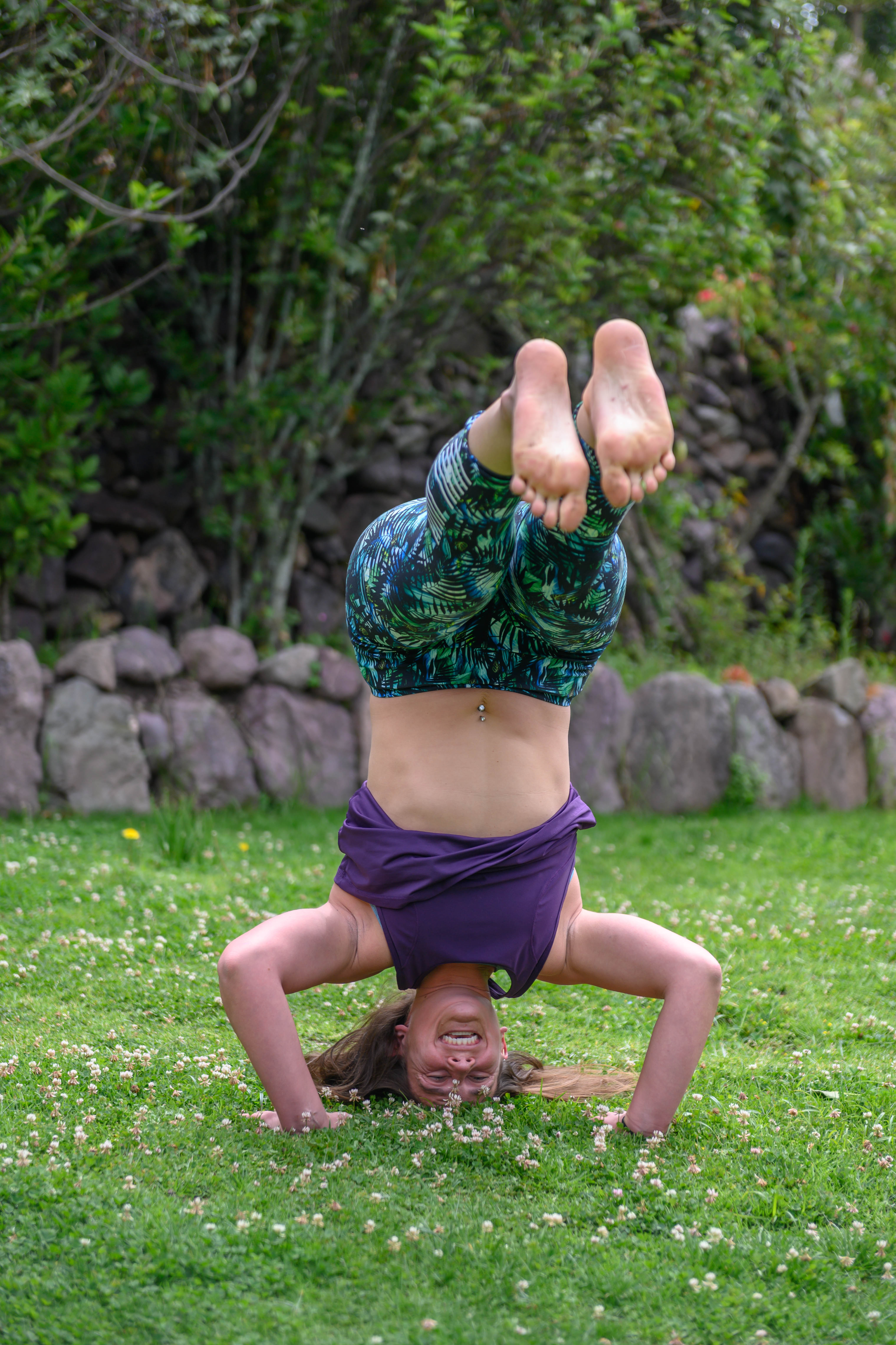 Elly doing a headstand on grass in the Sacred Valley of Peru
